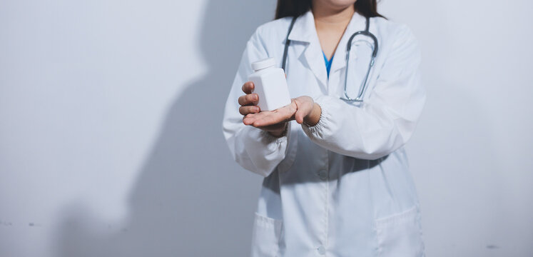 The pharmacist or doctor holding medication or medicine for treatment. Anti biotic pill in the vial.