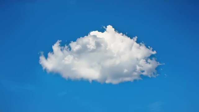A single fluffy white cumulus cloud floats serenely in a clear bright blue sky on a sunny day