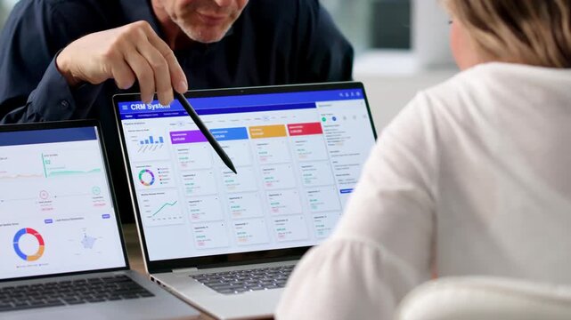 Sales Manager And Marketing Lead Discussing CRM Software