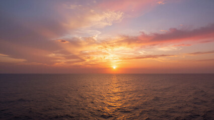 Fototapeta premium Sun dips low, painting sky in warm golds and pinks. Sea stretches wide, mirroring the fading daylight. Light dances on waves, soft and gentle. Moment holds still, peaceful and full of wonder