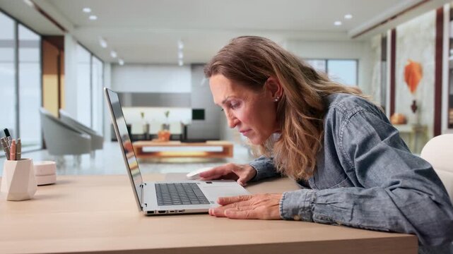 Older Woman Squints At Laptop Screen Feeling Tired