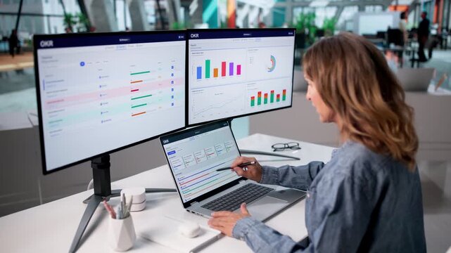 Senior Project Manager Reviews OKR Progress On Laptop