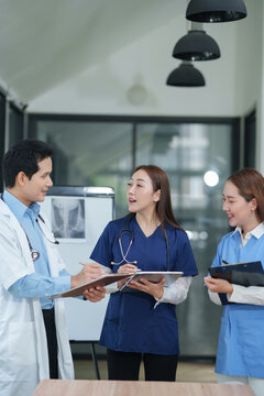 Medical Team Standing and Checking Patient Medical Records in Hospital