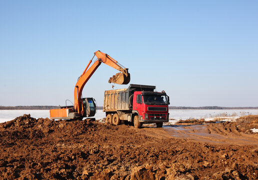 Construction - Yellow Excavator behind dump truck work