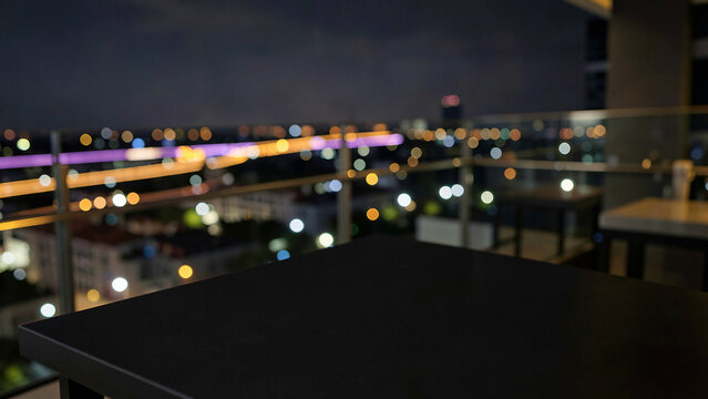 Matte Black Slate Table Surface on Modern Penthouse Balcony Bar with Glass Railings Luxury City Boke