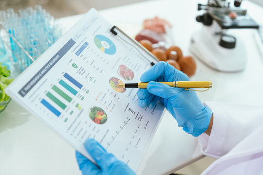 Food safety researcher reviewing nutrition and quality control reports in a laboratory, analyzing food data, testing results, and scientific performance metrics.