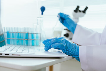 Fototapeta premium Laboratory scientist entering research data on a laptop in a modern lab, supporting sample analysis, quality control, scientific documentation, and laboratory workflow management.