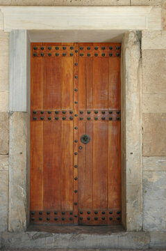 Ancient wooden door with metal studs and stone frame of the Stoa of Attalos in Athens Greece.