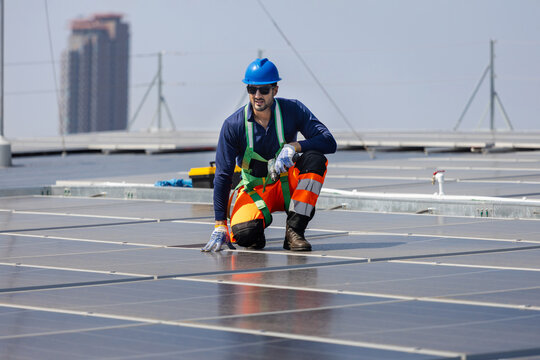 Workers inspecting solar panels on rooftop, Solar energy technicians installing photovoltaic panels on rooftop construction site, Professional engineering working on solar panel system installation
