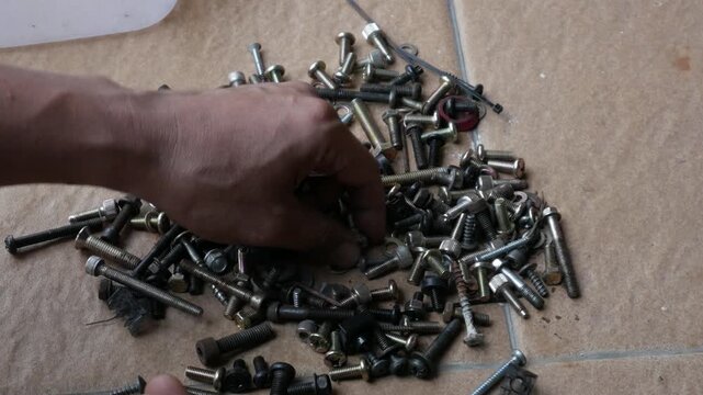 Hand Sorting Mixed Screws, Bolts and Nuts on Floor