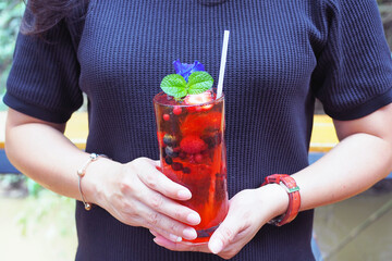 A refreshing glass of iced berry tea soda with mixed berries, strawberry, mint and butterfly pea. © Theerawan