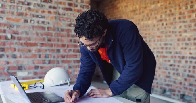 Writing, review and man with blueprint at construction site, planning update and change for renovation. Engineering, remodeling or architect with revision of schematic, laptop or property development