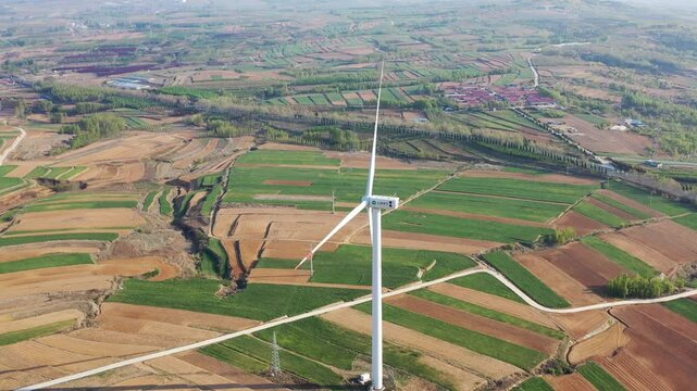 Wind turbine above patchwork farmland in the countryside