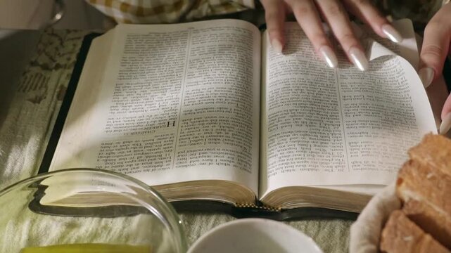 conservative Woman Reading the Bible at table with bread food and drink indoors