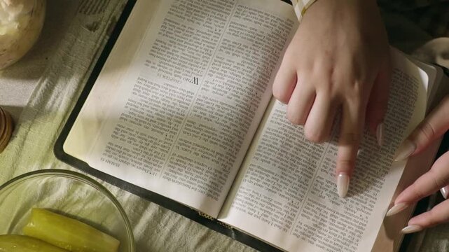 conservative Woman Reading the Bible at table with bread food and drink indoors