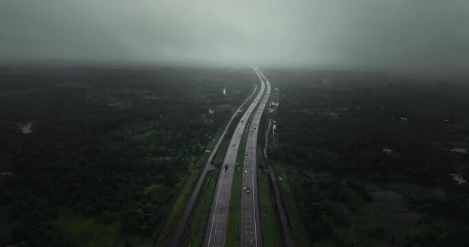 Aerial view of the Mumbai-Nagpur Expressway, also known as Samruddhi Mahamarg, captured during the monsoon season. The modern highway stretches through lush green landscapes and rain-soaked fields.