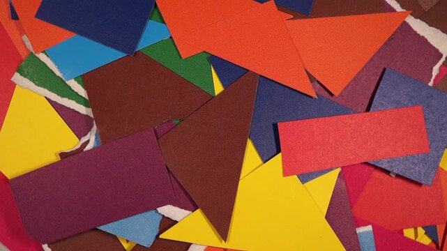 Rotation of colorful paper scraps on flat surface. Topview, copyspace, close-up