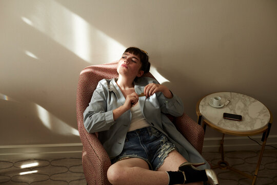 Teenage girl sitting in armchair looking away