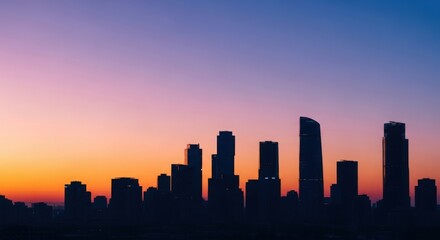 Fototapeta premium City skyline silhouette at sunset with vibrant colors and modern buildings against twilight sky. City skyline features high-rise architecture that enhances urban landscape during golden hour.
