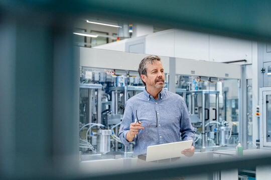 Engineer with laptop in modern factory automation environment