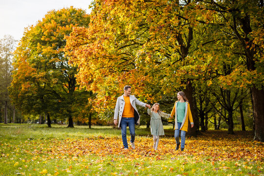 Family walking together in a park during autumn