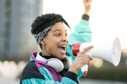 Young woman doing announcement through megaphone
