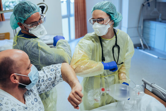 Doctors making elbow bump with cured patient in emergency care unit of a hospital