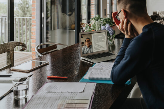Young man studying from home, using laptop