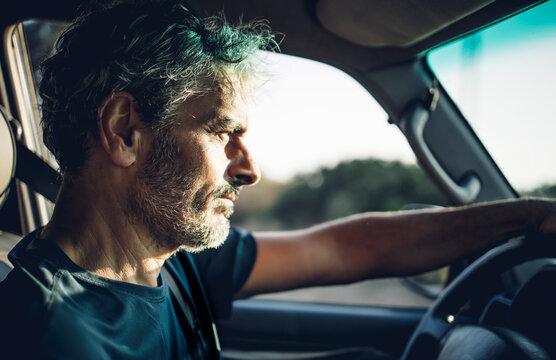 Mature man driving at sunset
