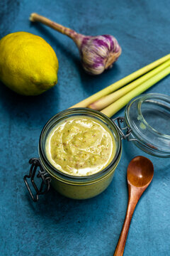 Homemade creamy lemon pesto in glass jar with garlic and lemongrass