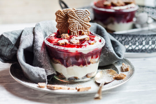 Glass of dessert of almond biscuits, Greek yoghurt and cranberry compote