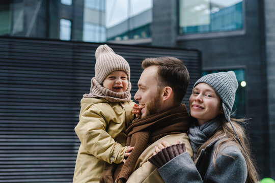 Happy father and mother with son standing in front of building
