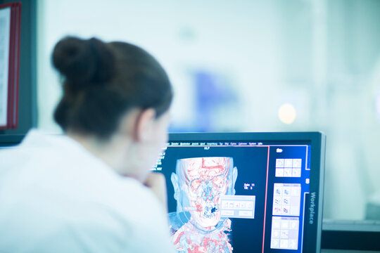 Young doctor in hospital looking at computer screen