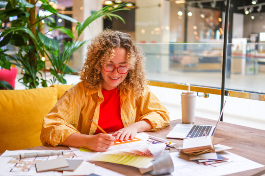 Architect smiling while drafting blueprint at biophilic workspace
