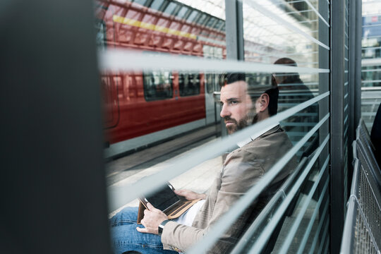 Young man with tablet waiting at the station platform