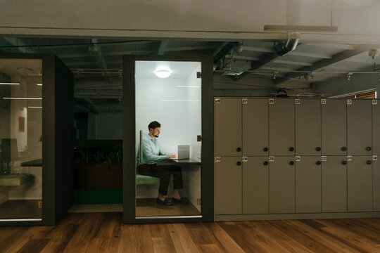 Businessman working online at laptop in private office workspace