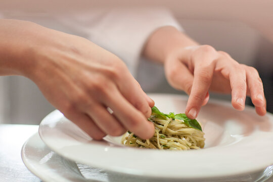 Chef garnishing plate with food