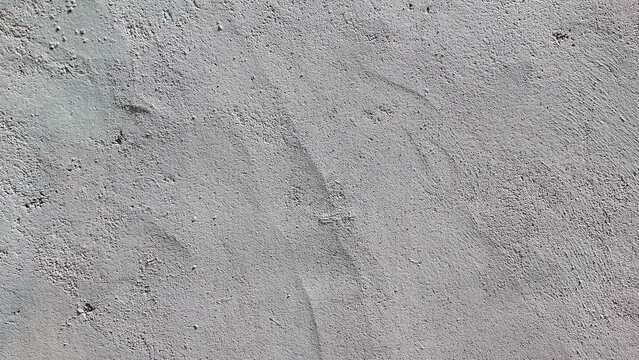 A smooth, minimalist light grey plaster wall showing subtle trowel marks and fine textures