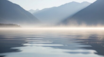 Fototapeta premium Serene lake reflection with misty mountains creating tranquil atmosphere over calm water. Mist enhances scenic beauty of lake surrounded by towering peaks, embodying peaceful outdoor experience.