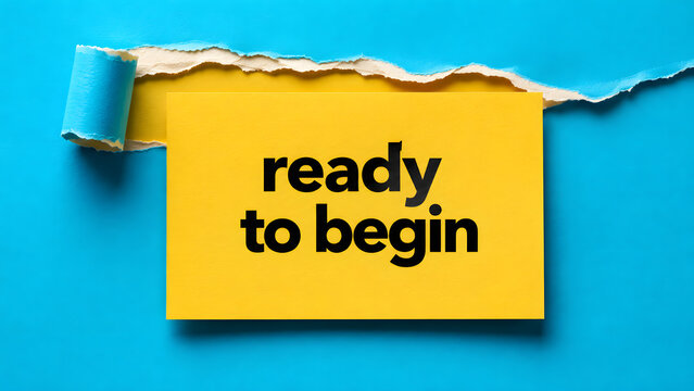 Ready to begin motivation text written on yellow paper card inside a ripped or torn blue paper background conceptual template for start business goal
