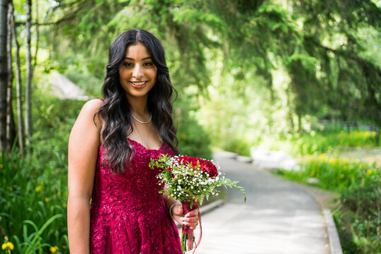 Smiling young woman in red dress in a park