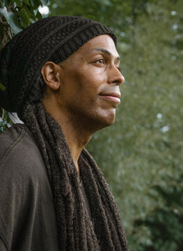 Thoughtful man with dreadlocks looking into the distance