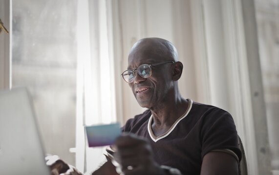 Senior black man shopping online with a credit card