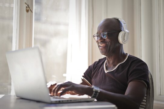 Smiling mature black man using a laptop computer at home