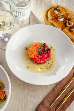 Gourmet salmon and tuna tartare dish with wine