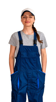 Adult female blue-collar worker wearing blue bib overalls and cap standing with hands in pockets.