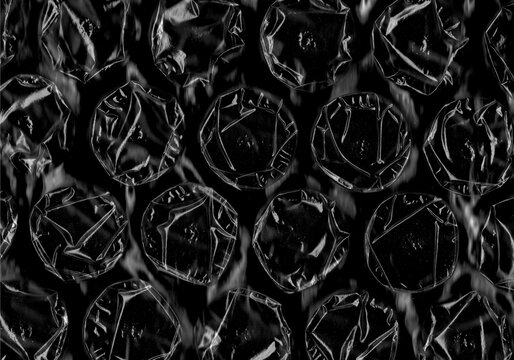 Black bubble wrap texture close up. Abstract protective packaging background ideal for shipping, logistics, design and industrial concepts.