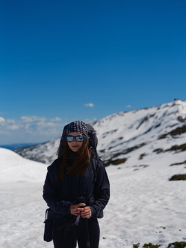 Hiker with backpack standing on snowy slope in Carpathians