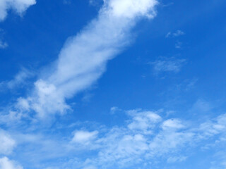Fototapeta premium A bright blue sky background with beautiful clouds; a bottom-down, wide-angle view.