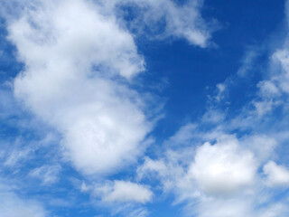 Obraz premium A bright blue sky background with beautiful clouds; a bottom-down, wide-angle view.